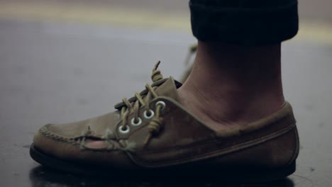 Lenta-de-la-persona-del-quebrado-zapato-mientras-espera-en-una-estación-de-metro