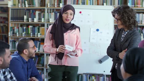 Mujer-alegre-en-Hijab-mostrando-tarjetas-de-palabra-en-lección