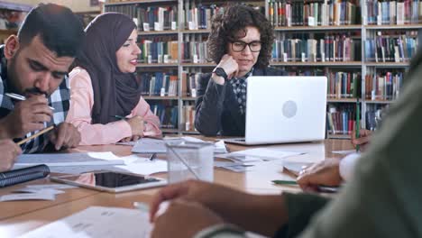 Lehrerin-auf-Laptop-tippen-und-die-Interaktion-mit-Erwachsenen-Migranten