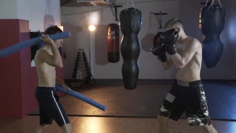 Rahmen-beschnitten,-bereitet-der-Athlet-für-den-Kampf.-Der-Coach-arbeitet-mit-der-Boxer-Geschwindigkeit-und-Genauigkeit-der-Auswirkungen.-Boxer-trainieren,-Boxhandschuhe,-Boxen-Birnen.-Das-Konzept-von-Sport,-Stärke,-Boxen,-Streiks,-Menschen