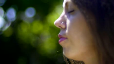 Primer-plano-cara-de-mujer-con-los-ojos-cerrados,-meditación-en-el-parque,-relajación-al-aire-libre