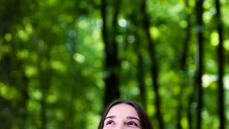 Smiling-woman-looks-up-happy-in-forest,-dreaming-feeling-joy-of-life,-happiness