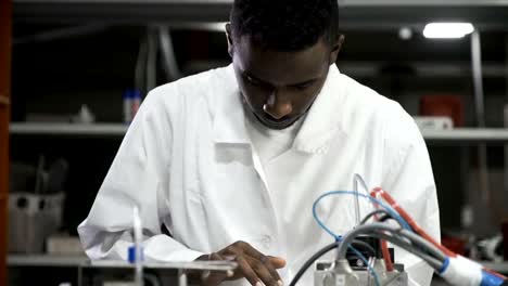 Engineer-examining-machine-with-tablet