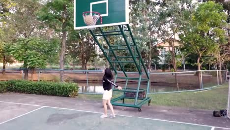 lenta-del-baloncesto-de-práctica-de-niña-en-el-patio-después-de-la-escuela