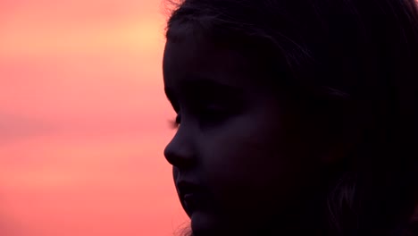 Niño-mirando-el-cielo-en-la-naturaleza.-Niña-rezando-mirando-hacia-arriba-en-el-cielo-púrpura-con-esperanza,-Close-up.