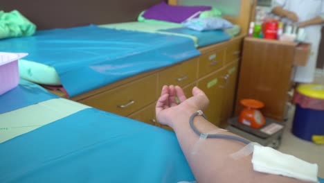 Blood-donation.-Male-hand-of-blood-donor-and-squeezing-rubber-ball-for-bumping-blood-in-hospital.