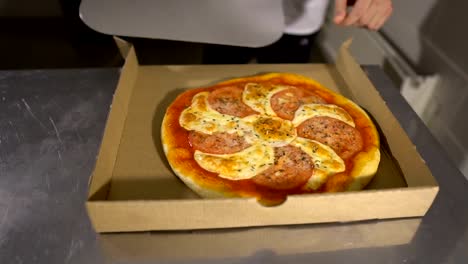 Pone-la-pizza-en-una-caja-de-cartón.-La-vista-desde-la-parte-superior.-Entrega-de-pizza.