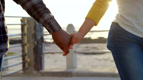 Mittelteil-des-Paares-zu-Fuß-mit-der-Hand-in-hand-auf-promenade-4k