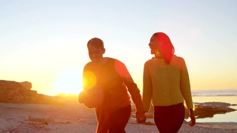 Pareja-caminando-cogidos-de-la-mano-en-la-playa-4k