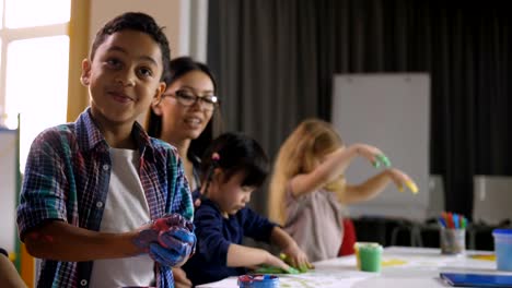 Cute-diverse-kids-painting-with-hands-at-lesson