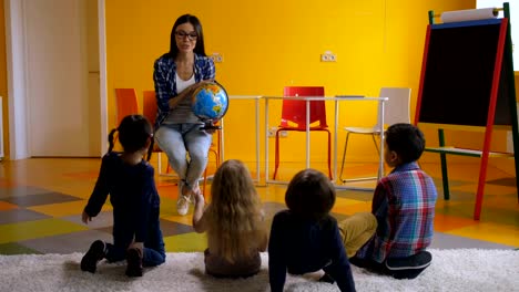 Preschool-teacher-teaching-kids-about-globe