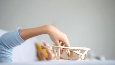 Slow-motion-footage-of-the-boy`s-hand-playing-with-wooden-plane-toy-model.-Vintage-transport-toys-concept-video.