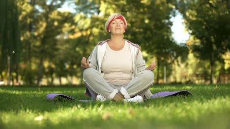 Middle-age-woman-deeply-breathing-and-meditating-sitting-in-lotus-position