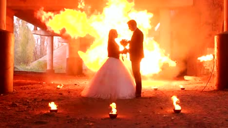 Couple-with-makeup-for-Halloween-at-a-party,-a-huge-fire-is-burning-nearby.