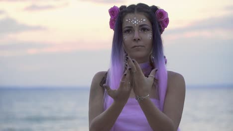 Tender-young-woman-with-sparkling-makeup-in-a-pink-dress-dancing-on-the-bank-of-the-river.-The-dance-of-a-sweet-sensual-lady-with-a-flower-hairstyle.-Slow-motion.