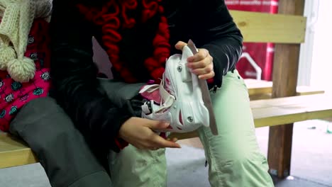 Little-Girl-and-Woman-Putting-on-Ice-Skates