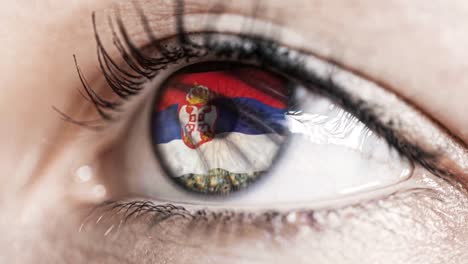 mujer-ojo-verde-en-primer-plano-con-la-bandera-de-Serbia-en-el-iris-con-el-movimiento-del-viento.-concepto-de-vídeo