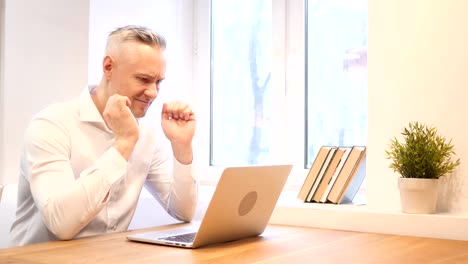 Middle-Age-Man-Upset-by-Loss-while-Working-on-Laptop