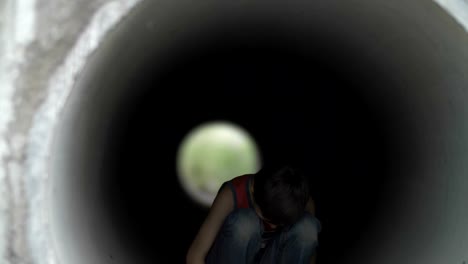 sad-lonely-boy-hiding-inside-of-a-drainage-tunnel,-lonely-homeless-boy-in-deep-depression