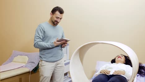 Doctor-talks-with-patient-during-magnetotherapy-in-clinic