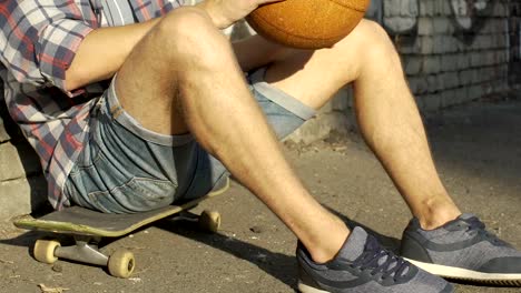 Teenage-boy-in-casual-clothing-sitting-on-skateboard,-active-leisure-time