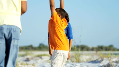 Ethnische-Eltern-und-Sohn-Baseball-zu-spielen,-am-Strand