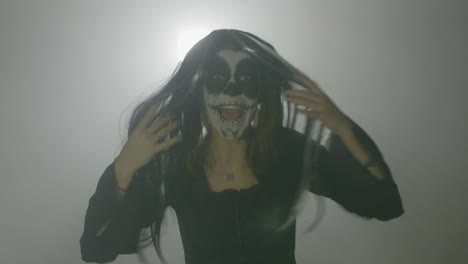 Bruja-escalofriante-zombie-mujer-mal-usar-una-peluca-y-un-maquillaje-espantoso-sobre-un-fondo-brumoso-día-de-los-muertos