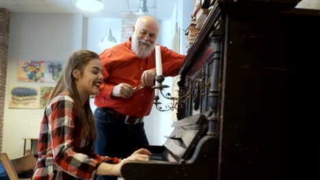 Hübsches-Mädchen-spielt-Klavier-für-ihr-Opa