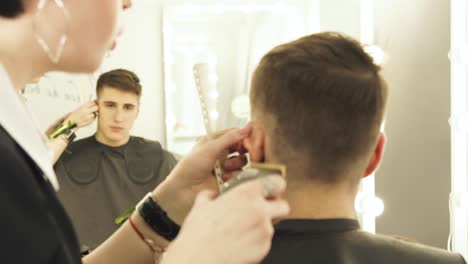 Haircutter-making-male-hair-cut-with-hair-clipper-and-comb-in-hairdressing-salon-close-up.-Hairdresser-doing-professional-hairstyle-with-electric-shaver
