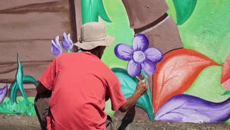 Pintor-mural-dibuja-jardín-en-la-pared-de-la-escuela