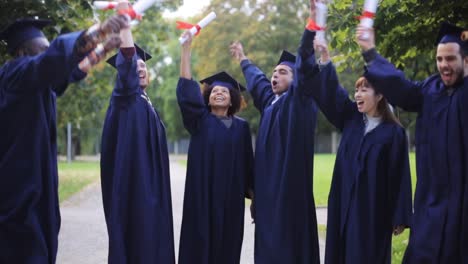 glückliche-Schüler-in-Mörtel-Boards-mit-Diplomen