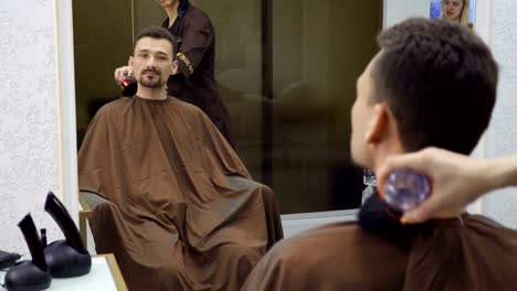 Hairdresser-cleans-man's-neck-after-cutting-hair