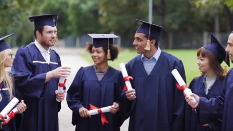 glückliche-Schüler-in-Mörtel-Boards-mit-Diplomen