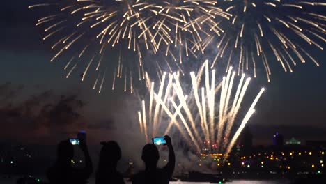 Eine-Gruppe-von-Leuten-während-ein-Feuerwerk-in-der-Nähe-eines-Flusses.-Festlichen-Feuerwerk.-Slow-motion