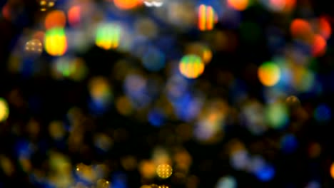 Defokussierten-schillernden-bunten-Glitter-Konfetti,-schwarzer-Hintergrund.-Urlaub-abstrakte-festliche-Bokeh-Lichtpunkte.