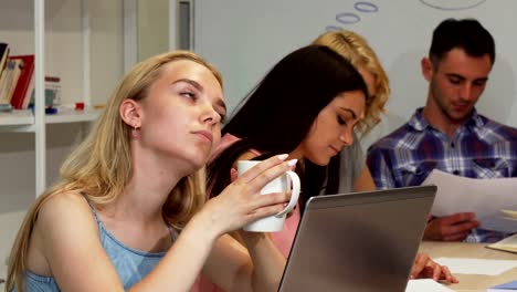 Young-businesswoman-looking-tired-while-working-with-her-team