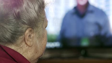 Nachrichten-Fernsehen-Senior-Frau.-Gesicht-der-älteren-Frau-vor-einem-TV-Bildschirm