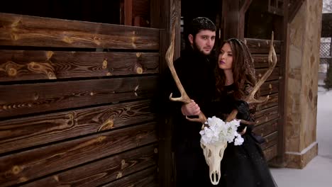 Couple-in-black-clothes-holding-a-skull-under-snow