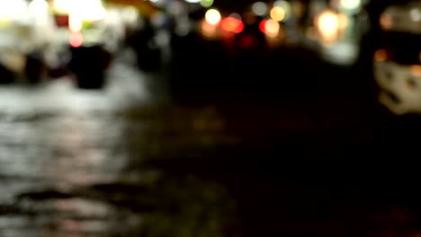 Lluvia-de-la-noche-con-coches-borrosos-en-fondo-de-carretera-de-inundación