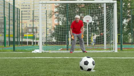 Senior-männlichen-Torhüter-fangen-Fußball