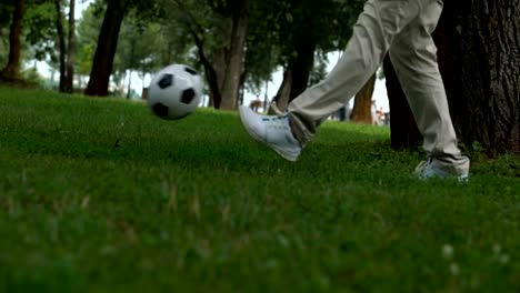 Dad-and-son-playing-football,-accustoms-child-to-active-and-healthy-lifestyle