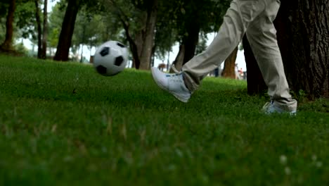 Padre-e-hijo-jugando-al-fútbol,-acostumbra-infantil-al-estilo-de-vida-activo-y-saludable