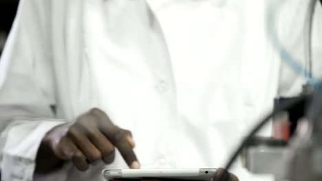 Engineer-examining-machine-with-tablet