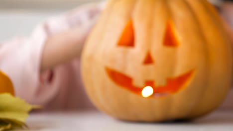 Girl-showing-carved-jack-pumpkin-with-burning-candle-inside,-preparing-for-party