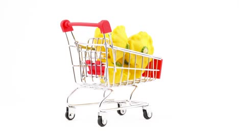 Supermarket-trolley.-Shopping-cart-with-yellow-pattypan-squashes.-Rotating.-Isolated-on-the-white-background.-Close-up.-Macro.