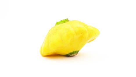 One-yellow-patisson-squash-with-water-drops.-Rotating-on-the-turntable.-Isolated-on-the-white-background.-Close-up.-Macro.
