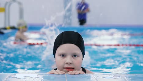 Schwimmkurse-für-Kinder-in-den-Pool---schönes-hellhäutige-Mädchen-im-Wasser-schwimmt