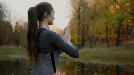 Young-woman-practicing-yoga-outdoors.-Female-meditate-outdoor-infront-of-beautiful-autumn-nature