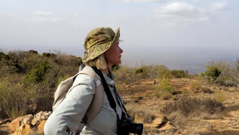 Frau-Tourist-mit-einer-Kamera-ist-es-lohnt-ein-Blick-auf-die-Landschaft-genießen