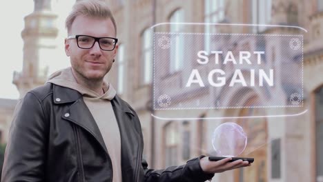 Smart-young-man-with-glasses-shows-a-conceptual-hologram-Start-Again